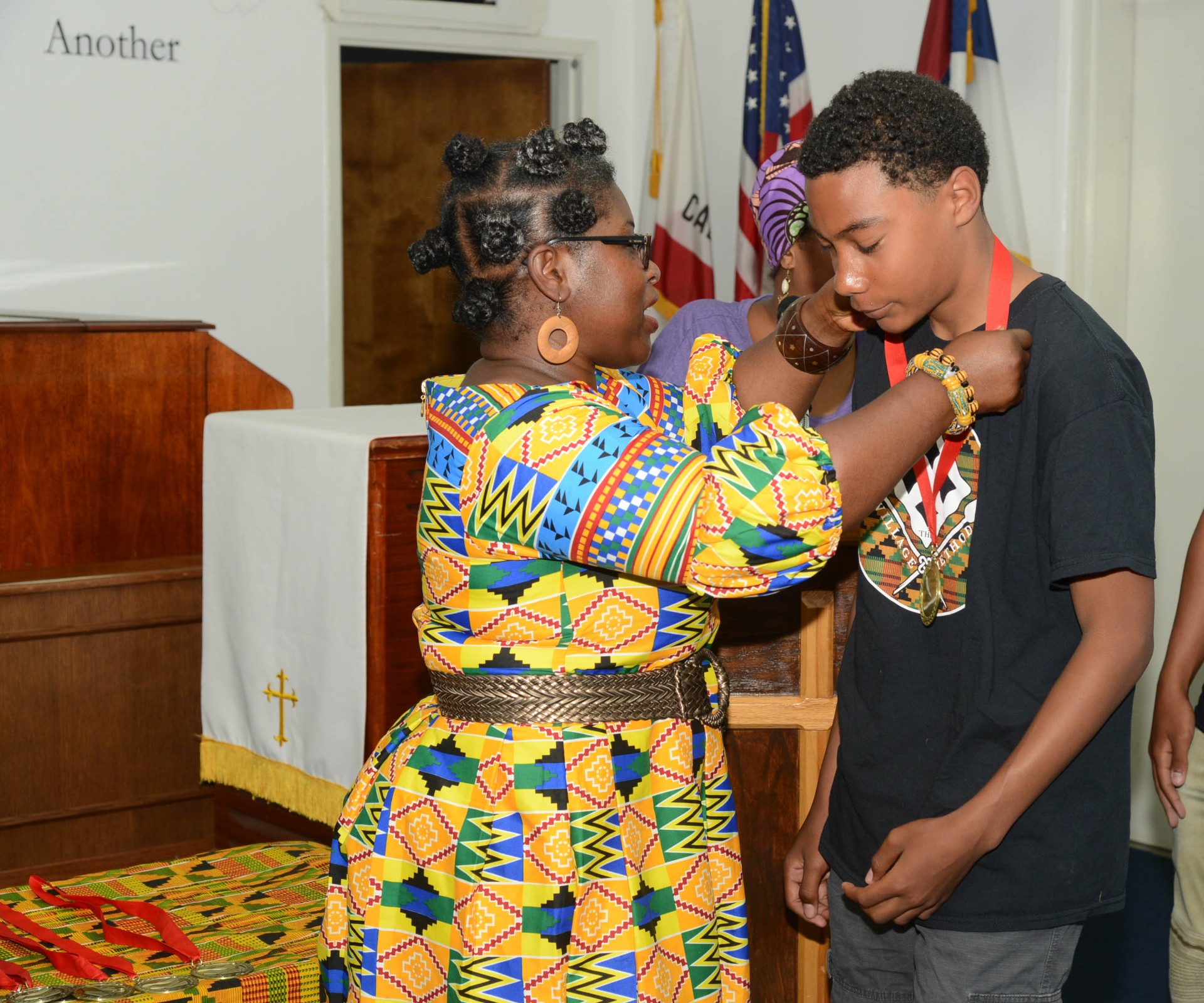 A scholar receiving a medal from an elder